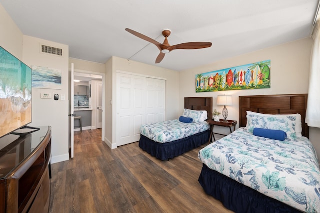 bedroom with ceiling fan, a closet, and dark hardwood / wood-style flooring