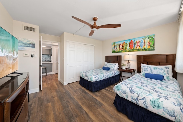 bedroom featuring a ceiling fan, baseboards, visible vents, dark wood-style floors, and a closet