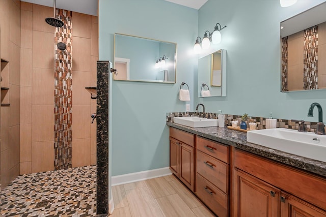 bathroom with double vanity, walk in shower, and a sink