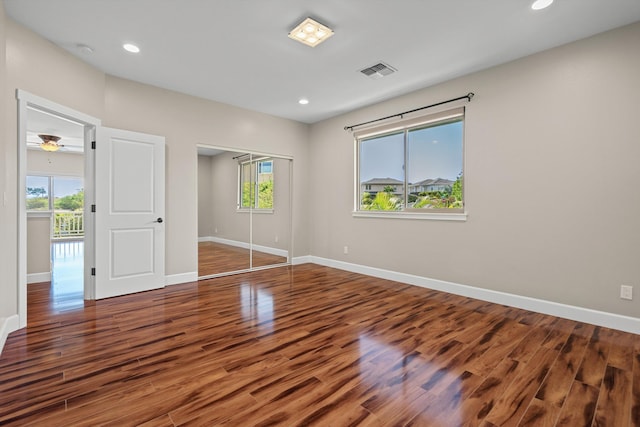 unfurnished bedroom with visible vents, baseboards, recessed lighting, wood finished floors, and a closet