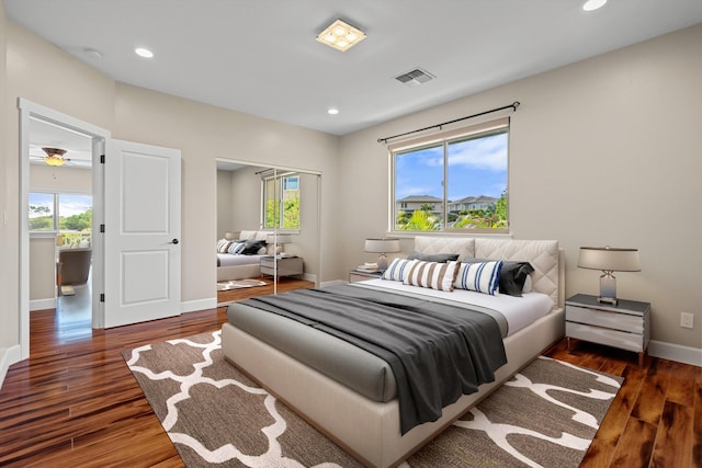 bedroom featuring visible vents, multiple windows, and wood finished floors