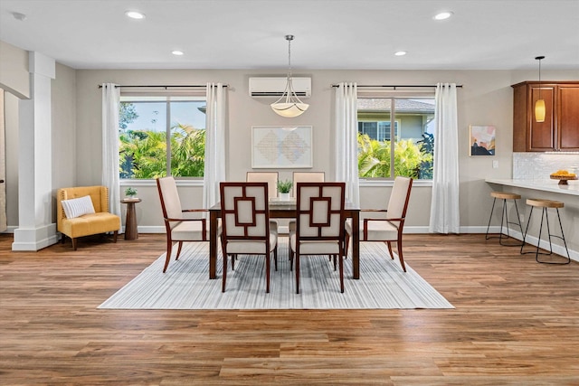 dining space with a healthy amount of sunlight, recessed lighting, wood finished floors, and a wall mounted AC