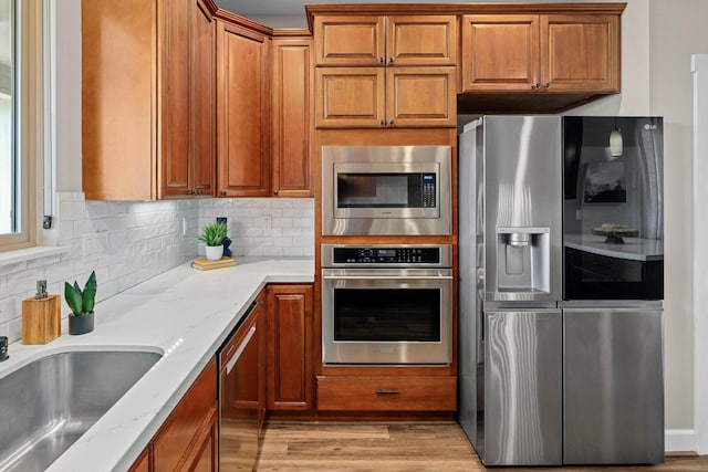 kitchen with brown cabinets, appliances with stainless steel finishes, and a sink