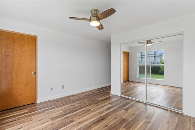 unfurnished bedroom featuring hardwood / wood-style flooring, ceiling fan, and a closet