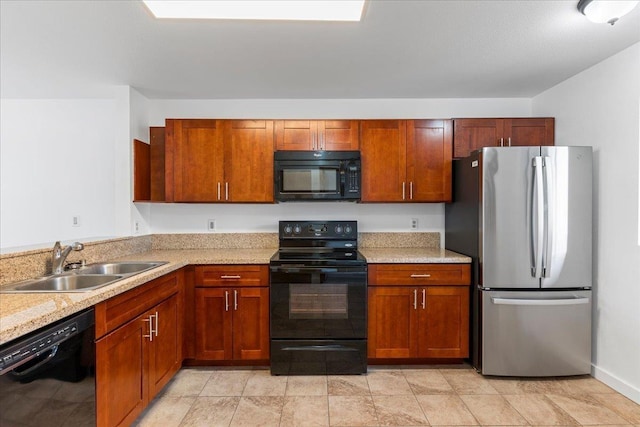 kitchen featuring light stone counters, sink, and black appliances