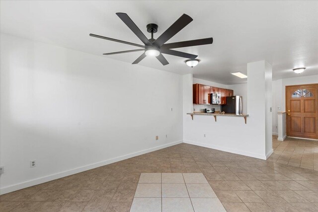 unfurnished living room with ceiling fan and light tile patterned flooring