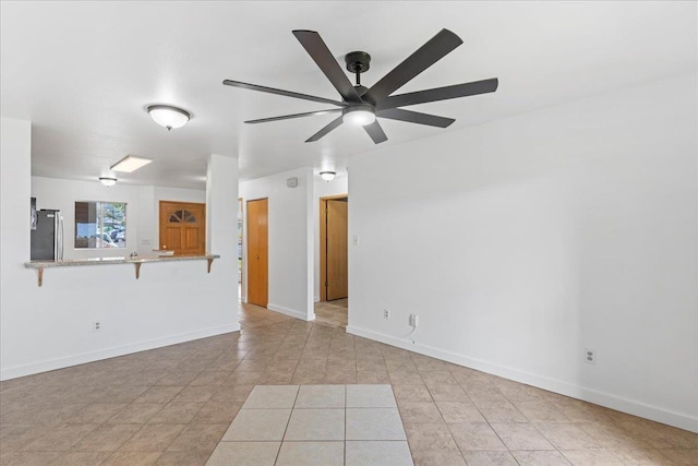 spare room with ceiling fan and light tile patterned flooring