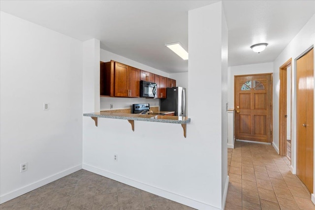 kitchen featuring stainless steel appliances, a kitchen bar, and kitchen peninsula