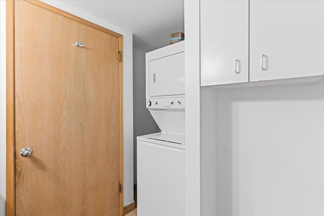 laundry area featuring stacked washing maching and dryer and laundry area