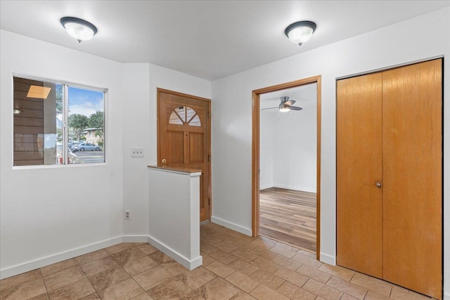 entrance foyer featuring a ceiling fan and baseboards