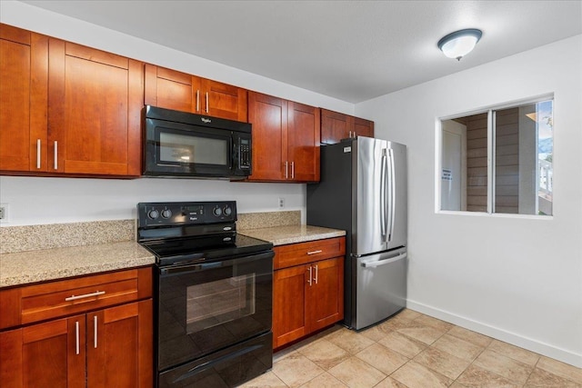 kitchen featuring light stone countertops and black appliances