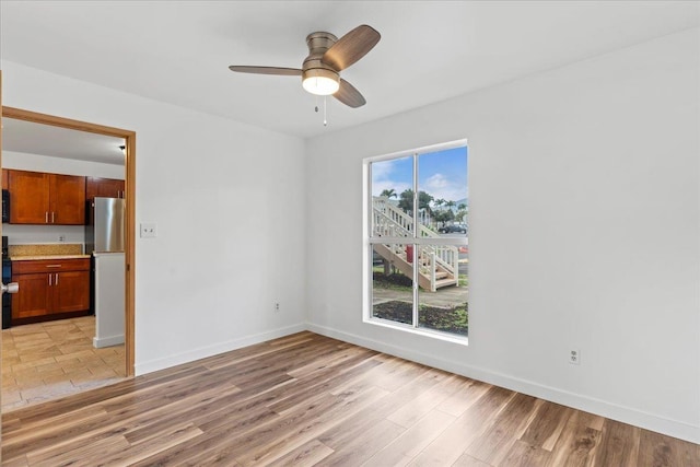 empty room with ceiling fan and light wood-type flooring