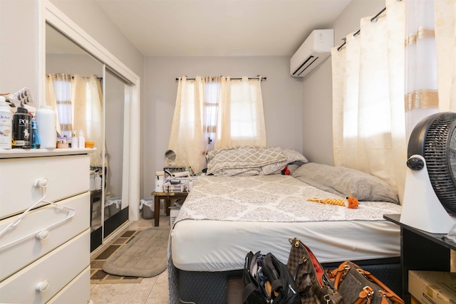 bedroom with light tile patterned floors and a wall mounted air conditioner