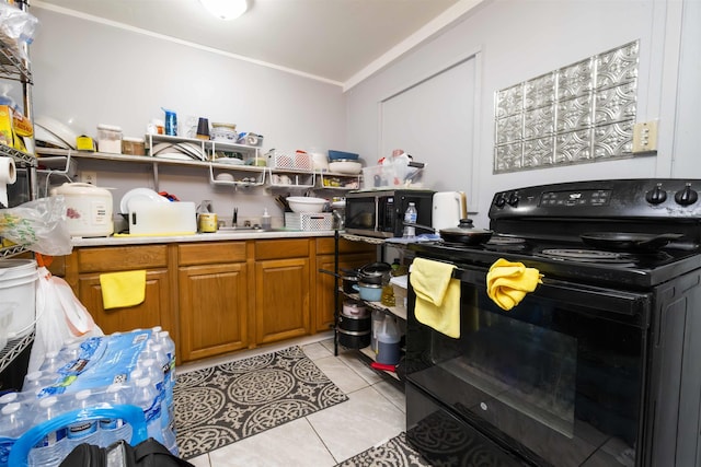 laundry room featuring crown molding and light tile patterned floors