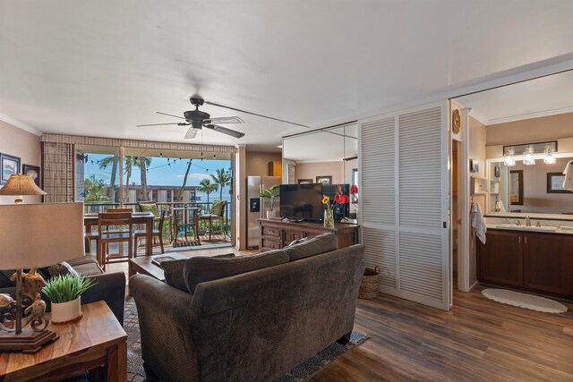 living room featuring ceiling fan, crown molding, and dark wood-type flooring