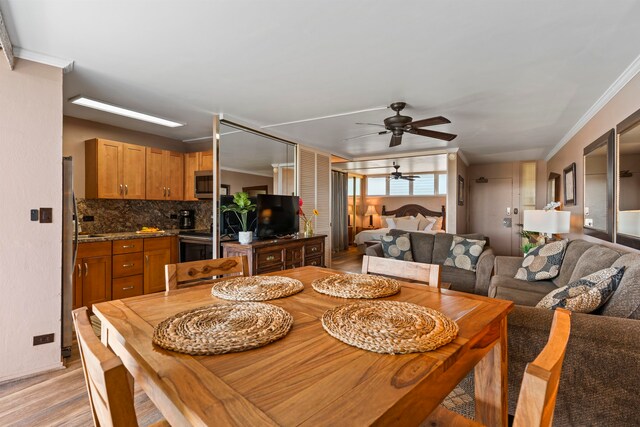 dining space with crown molding, light hardwood / wood-style flooring, and ceiling fan