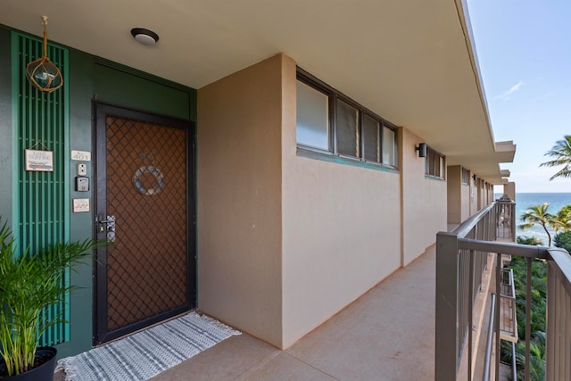 entrance to property with a water view and a balcony