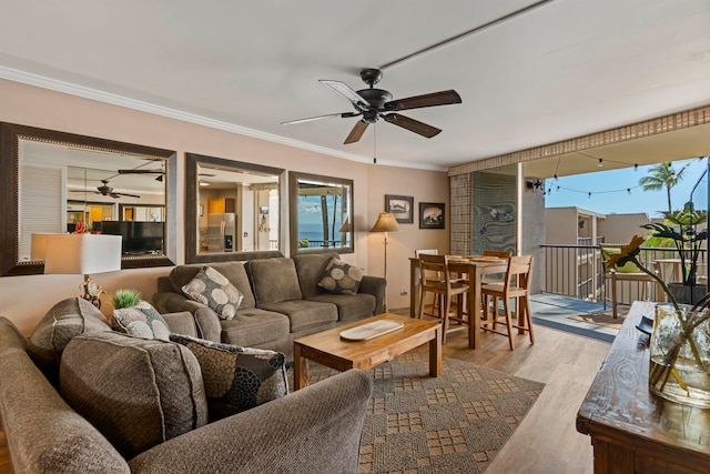 living room with ceiling fan, crown molding, a wealth of natural light, and light hardwood / wood-style flooring