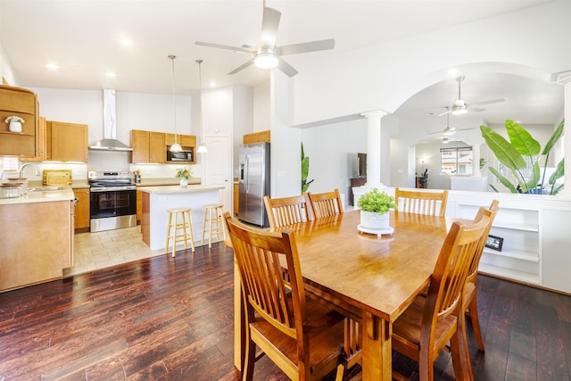 dining space with a ceiling fan, ornate columns, arched walkways, light wood-style floors, and recessed lighting