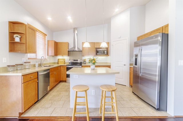 kitchen with stainless steel appliances, a sink, wall chimney range hood, a kitchen island, and a breakfast bar