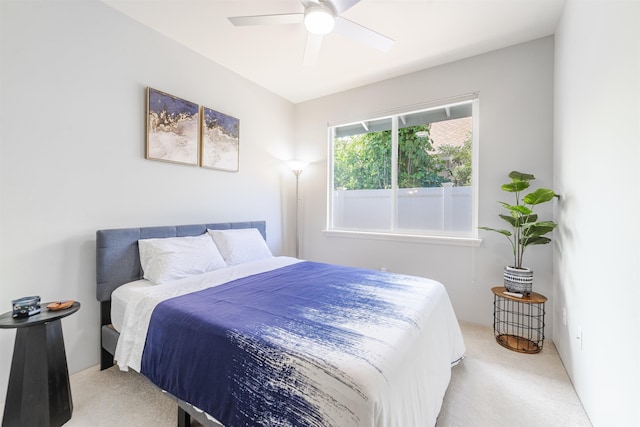 bedroom with light colored carpet and a ceiling fan