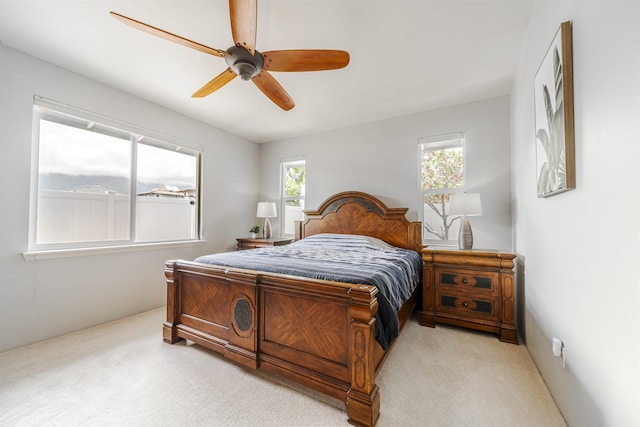 bedroom with multiple windows, light carpet, and ceiling fan