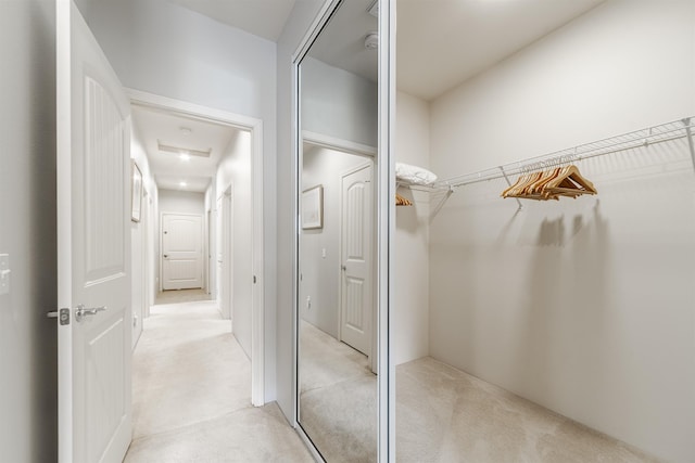 walk in closet featuring light carpet