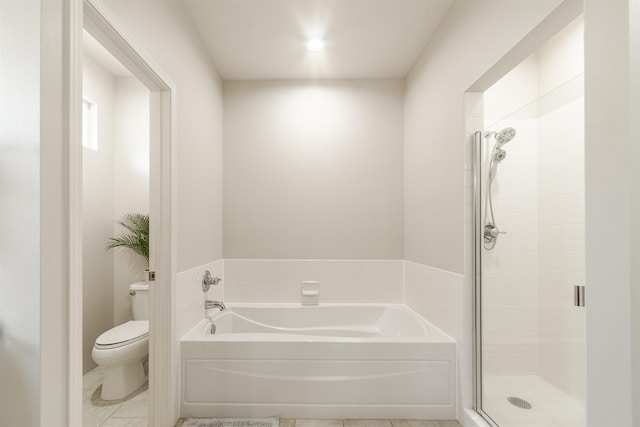 bathroom featuring toilet, a garden tub, a stall shower, and tile patterned flooring