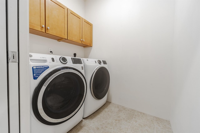laundry area featuring separate washer and dryer and cabinet space