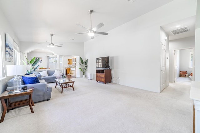 living area featuring plenty of natural light, light colored carpet, and ceiling fan