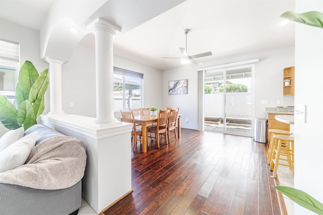 dining area with decorative columns, dark wood-style floors, and ceiling fan