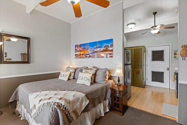 bedroom featuring beamed ceiling, stainless steel refrigerator, ceiling fan, and light wood-type flooring