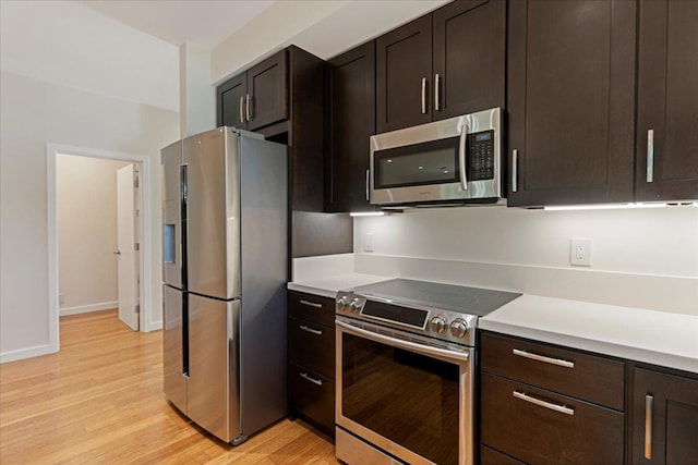 kitchen with light countertops, light wood-style flooring, baseboards, stainless steel appliances, and dark brown cabinets