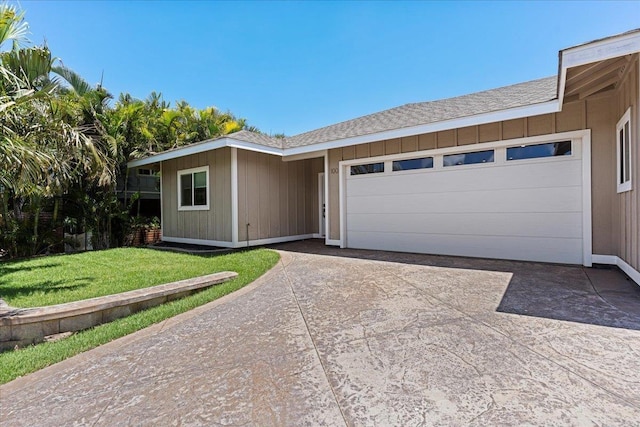ranch-style house featuring a front yard, an attached garage, and concrete driveway