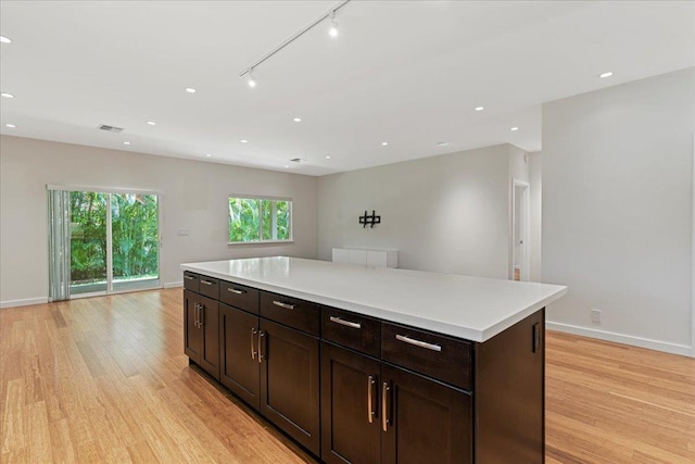 kitchen with baseboards, open floor plan, and light wood finished floors