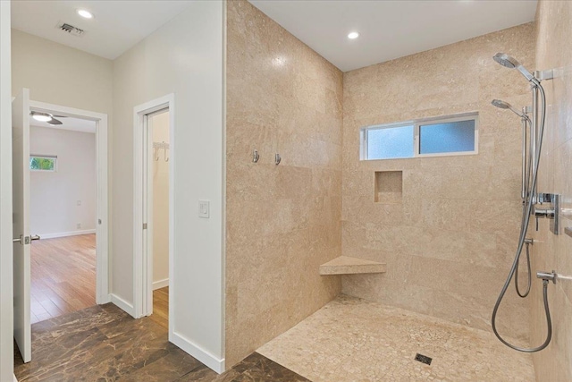 full bath with recessed lighting, baseboards, a tile shower, and visible vents