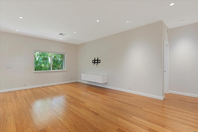 empty room with baseboards, recessed lighting, and light wood-type flooring