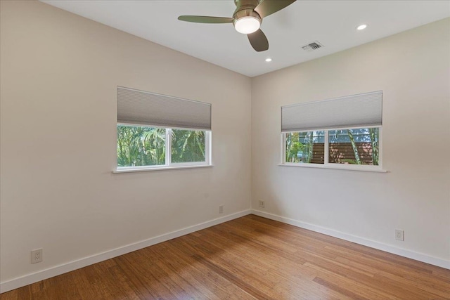 empty room with a ceiling fan, wood finished floors, baseboards, visible vents, and recessed lighting