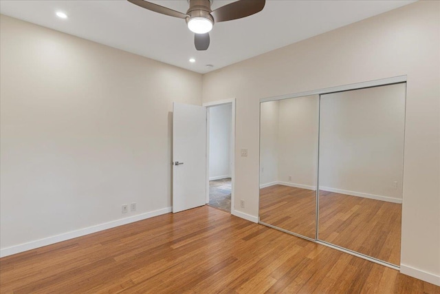 unfurnished bedroom with a ceiling fan, a closet, baseboards, and light wood-type flooring