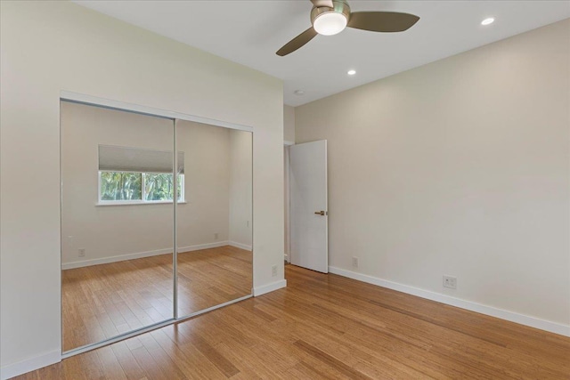 unfurnished bedroom with a closet, a ceiling fan, wood finished floors, baseboards, and recessed lighting