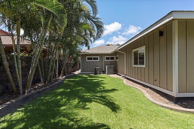 view of yard featuring central AC unit and fence