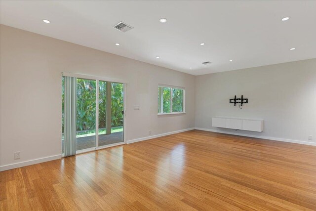 empty room featuring baseboards, visible vents, light wood-style flooring, and recessed lighting