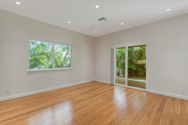 empty room featuring baseboards, visible vents, and light wood-type flooring