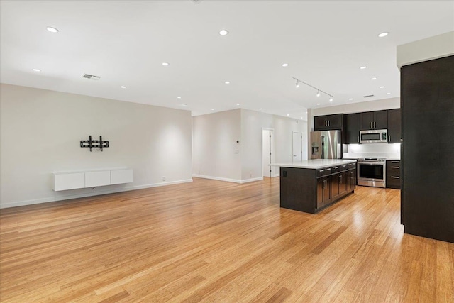 kitchen with light wood-type flooring, a kitchen island, stainless steel appliances, and visible vents