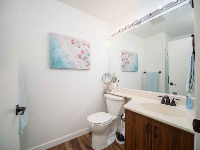 bathroom with hardwood / wood-style flooring, vanity, and toilet