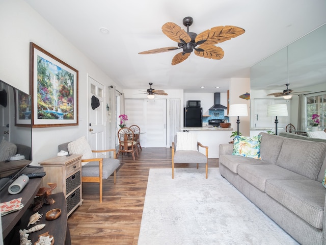 living room featuring ceiling fan and dark hardwood / wood-style floors