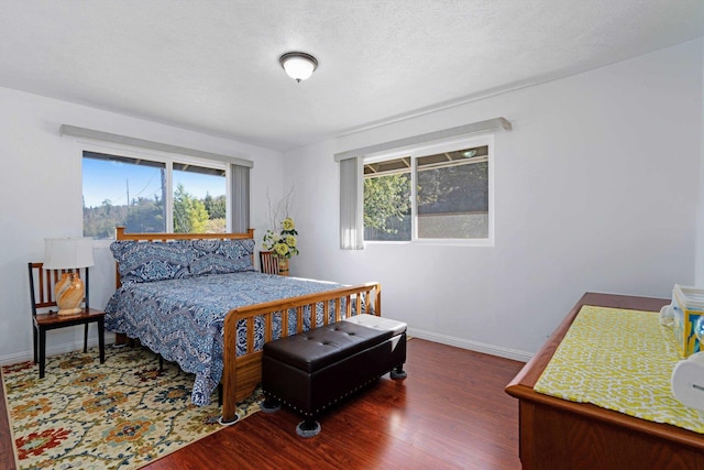 bedroom with a textured ceiling and dark wood-type flooring