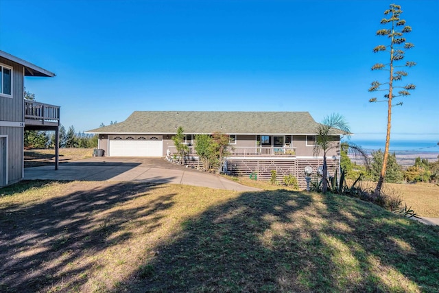 single story home with covered porch, a garage, and a front lawn