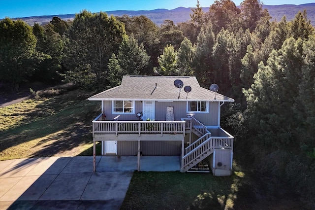 ranch-style home with a mountain view, a garage, and a front yard