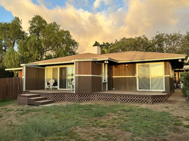 back house at dusk featuring a yard